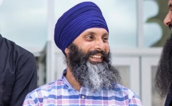 Un groupe d'hommes sikhs se parle de manière informelle pour une photographie posée.