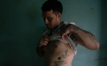 Rodríguez soulève sa chemise pour montrer certains de ses tatouages.