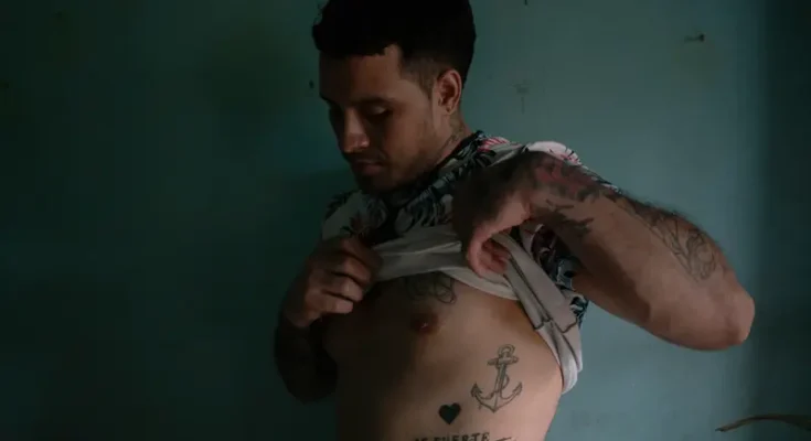 Rodríguez soulève sa chemise pour montrer certains de ses tatouages.