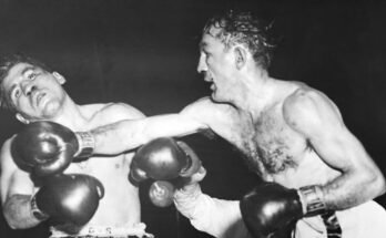 (Légende d'origine) 12/1/1955-Boston, MA-Challenger Tony DeMarco est secoué avec une croix droite jusqu'au menton par Carmen Basilio. C'était la fatigue 12. Pour Tony qui a essayé de retrouver la couronne de puits qu'il a perdue contre Carmen l'année dernière. Cette bataille a été une infraction instantanée à la finale qui a mis fin à Tony hier soir au Boston Garden. Carmen a marqué un TKO à. 1:54 de ce tour lorsque le juge a arrêté le massacre.