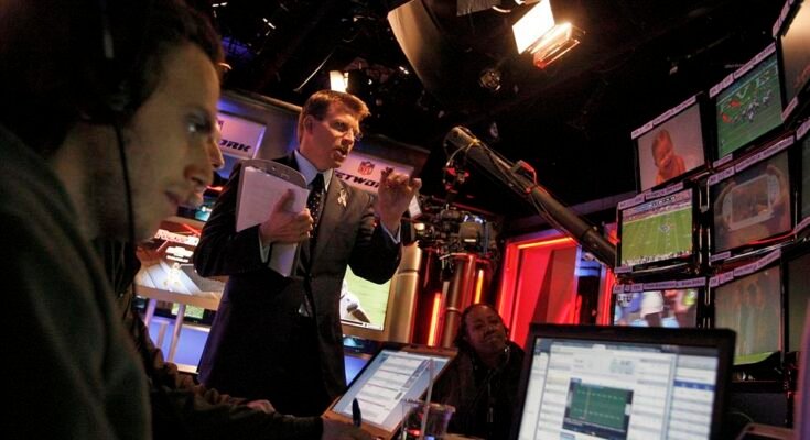 Scott Hanson (Mid), menant l'ancrage au NFL Redzone Network, photographié pendant le dimanche B