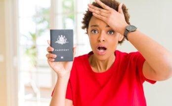 Une jeune femme afro-américaine qui détient des passeports australiens, stressé par la tête, choqué par la honte et le visage surprenant, en colère et frustré. Peur et dérangée pour les erreurs.