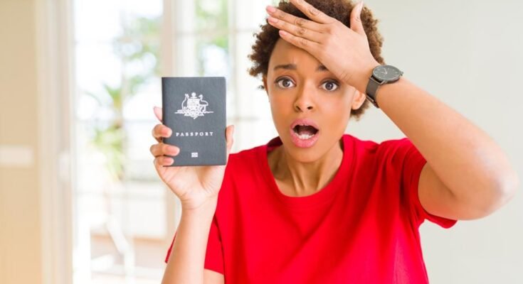Une jeune femme afro-américaine qui détient des passeports australiens, stressé par la tête, choqué par la honte et le visage surprenant, en colère et frustré. Peur et dérangée pour les erreurs.