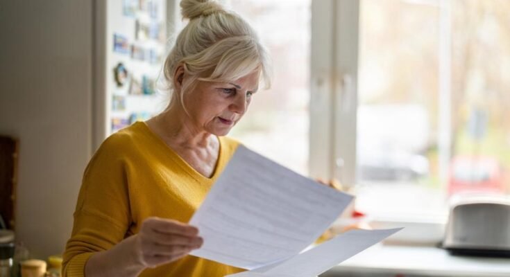 Femme âgée qui remplit des comptes