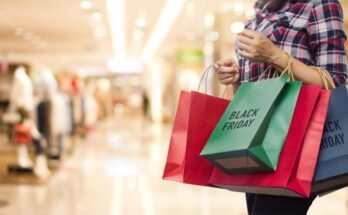 Black Friday, femme qui détient de nombreux sacs à provisions tout en allant au centre du centre commercial.