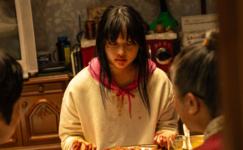 Une adolescente zombie s'assoit pour manger un repas humain.