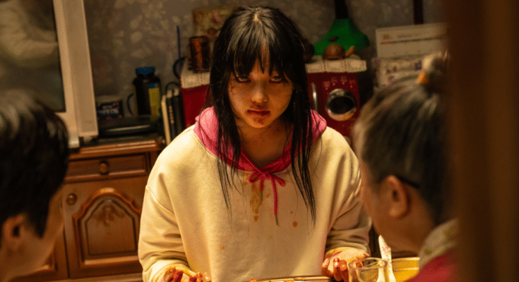 Une adolescente zombie s'assoit pour manger un repas humain.