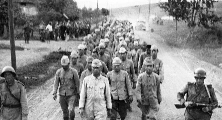 Des rangées de personnes en uniformes qui descendent une route