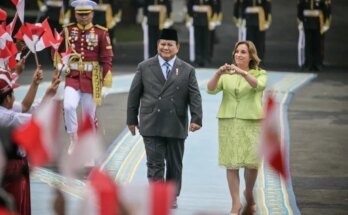 Le président indonésien Prabowo Subianto et la présidente péruvienne Dina Boluare voient les enfants agiter les drapeaux de leur pays avant leur réunion au Palais de Merdeka à Jakarta le 11 août.