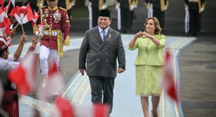 Le président indonésien Prabowo Subianto et la présidente péruvienne Dina Boluare voient les enfants agiter les drapeaux de leur pays avant leur réunion au Palais de Merdeka à Jakarta le 11 août.