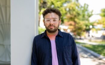 Portrait de Nikita Bezrukov, qui se tient à l'extérieur, appuyé contre un pilier