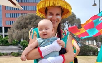 Le Dr Maria del Mar Quiroga vêtue du costume du festival argentin et tient son fils.