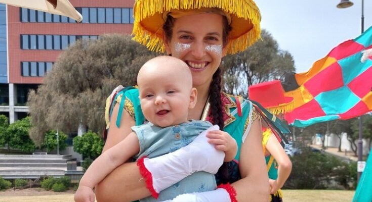 Le Dr Maria del Mar Quiroga vêtue du costume du festival argentin et tient son fils.