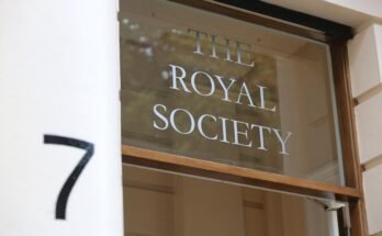 Un gros plan du logo de la Royal Society apparaît sur une fenêtre en verre sur une porte avec un numéro flou «7» au premier plan