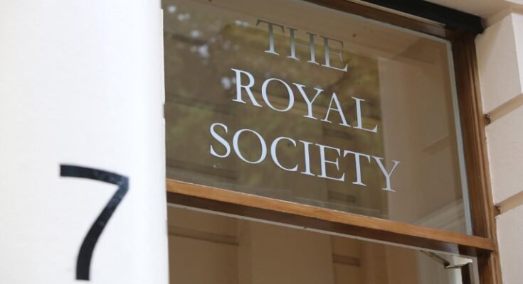 Un gros plan du logo de la Royal Society apparaît sur une fenêtre en verre sur une porte avec un numéro flou «7» au premier plan