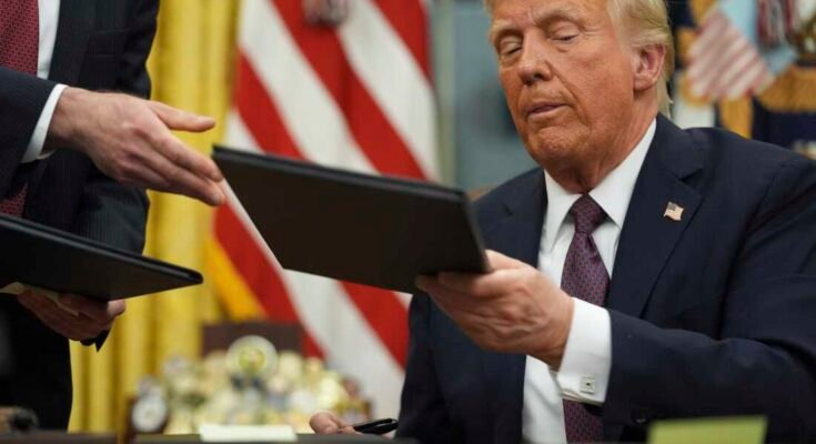 Le président Donald Trump signe des décrets dans le bureau ovale de la Maison Blanche le 20 janvier.